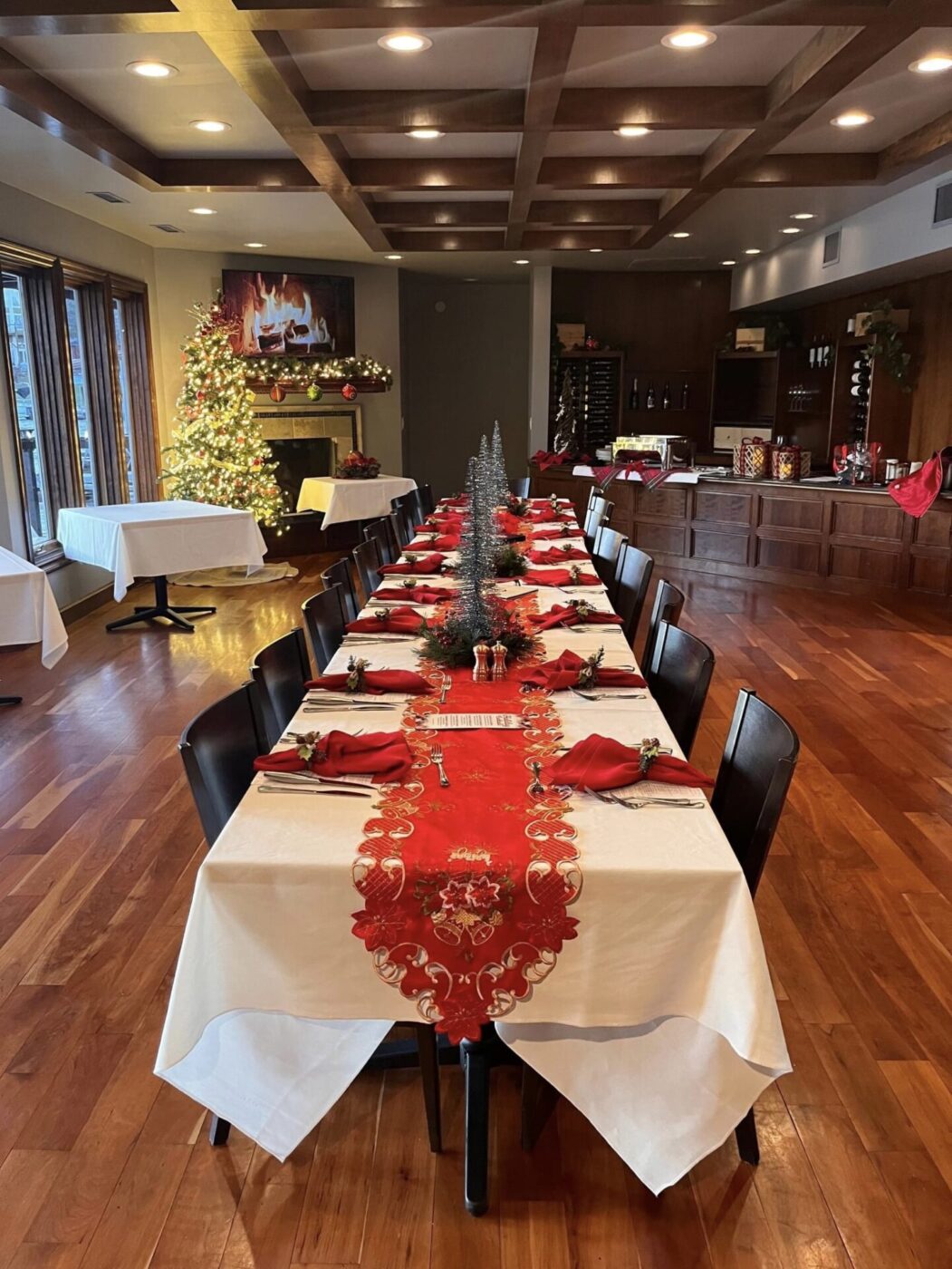 The interior of Marina 27 Steak & Seafood during Christmas time with festive decor on the table and a tree in the background.