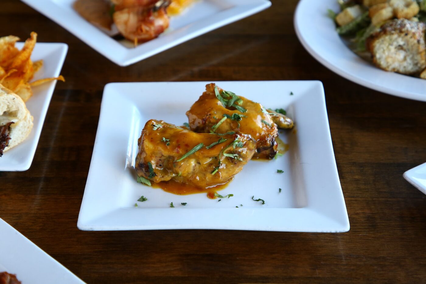 Spicy, marinated chicken thighs tossed in a signature spicy sauce with garnishes on top.