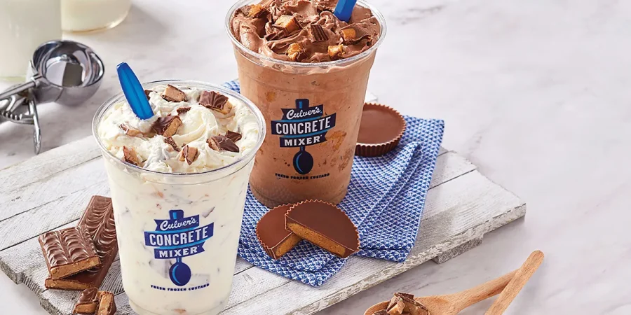 Two Culver's concrete mixers - one filled with chocolate and one filled with vanilla - both topped with delicious candy.