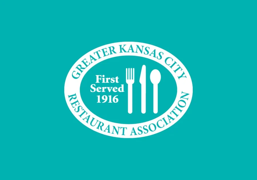 Greater Kansas City Restaurant Association logo with text in all white and the words first served in 1916 by a fork, knife, and spoon.